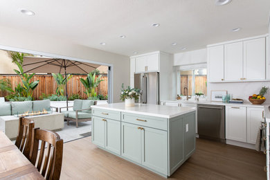 Eat-in kitchen - modern l-shaped porcelain tile and brown floor eat-in kitchen idea in Orange County with an undermount sink, shaker cabinets, white cabinets, quartzite countertops, white backsplash, quartz backsplash, stainless steel appliances, an island and white countertops