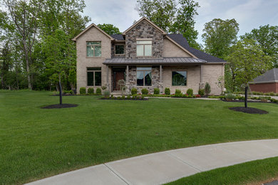 Inspiration for a large contemporary beige two-story brick gable roof remodel in Other