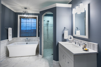 Mid-sized arts and crafts master gray tile and marble tile ceramic tile and white floor bathroom photo in Other with recessed-panel cabinets, white cabinets, blue walls, an undermount sink, quartz countertops and white countertops