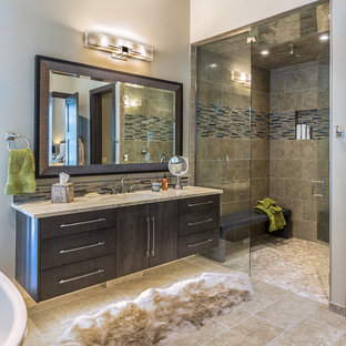 Foto di una grande stanza da bagno padronale moderna con ante lisce, ante grigie, doccia aperta, piastrelle beige, piastrelle di vetro, pareti beige, pavimento in travertino, lavabo sottopiano e top in granito