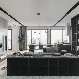 Large trendy light wood floor and beige floor living room photo in New York with gray walls and a wall-mounted tv