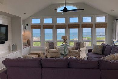 Inspiration for a large beach style enclosed family room in Other with grey walls, no fireplace and a wall-mounted tv.