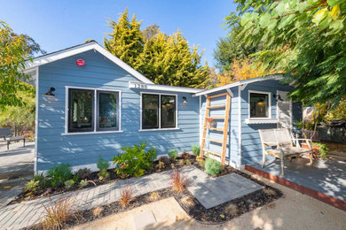 Example of a small beach style blue one-story wood house exterior design in Orange County with a shingle roof and a gray roof