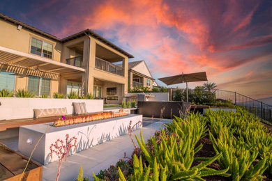 Imagen de patio contemporáneo de tamaño medio en patio trasero con brasero, adoquines de hormigón y pérgola