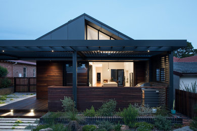 Exempel på ett mellanstort modernt brunt hus, med allt i ett plan och valmat tak