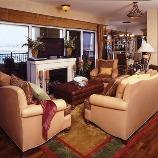 Small mediterranean formal open plan living room in San Diego with beige walls, medium hardwood flooring, a standard fireplace, a stone fireplace surround and a freestanding tv.