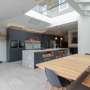 Foto de cocina comedor actual, grande, con armarios con paneles lisos, puertas de armario grises, encimera de mármol, salpicadero verde, salpicadero de mármol, electrodomésticos de acero inoxidable, una isla, suelo gris y encimeras grises