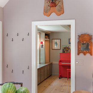 Eklektisk inredning av ett kapprum, med lila väggar, ljust trägolv och en enkeldörr