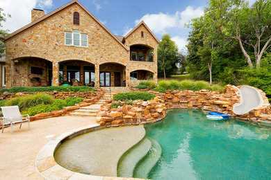 Inspiration for a mid-sized mediterranean backyard custom-shaped and stone natural water slide remodel in Dallas