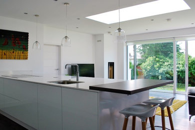 Contemporary kitchen in Belfast with an integrated sink, flat-panel cabinets and white cabinets.