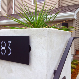 Photo of a mid-sized modern front yard partial sun driveway for winter in Providence with concrete pavers.