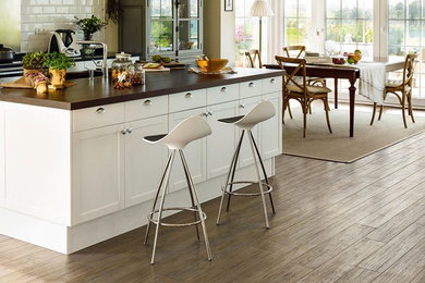 Mid-sized transitional galley porcelain tile open concept kitchen photo in Chicago with shaker cabinets, white cabinets, wood countertops, white backsplash, subway tile backsplash, stainless steel appliances and an island