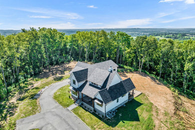 Large cottage white three-story mixed siding and board and batten exterior home idea in Nashville with a shingle roof and a black roof