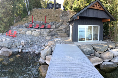 Inspiration for a huge traditional partial sun hillside stone retaining wall landscape in Other for summer.