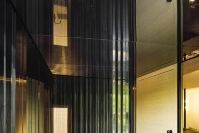 Mittelgroße Moderne Haustür mit schwarzer Wandfarbe, Einzeltür, heller Holzhaustür, grauem Boden und vertäfelten Wänden in München