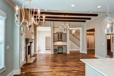 Family room - large transitional open concept dark wood floor family room idea in Other with beige walls, a standard fireplace, a stone fireplace and no tv