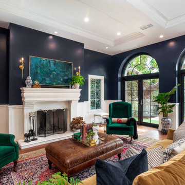 Elegant Traditional Living Room with Navy Walls, Fireplace, and Arched French Do