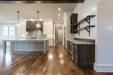 Photo of a large country l-shaped open plan kitchen in Atlanta with a farmhouse sink, recessed-panel cabinets, white cabinets, granite benchtops, blue splashback, subway tile splashback, stainless steel appliances, dark hardwood floors, with island and brown floor.