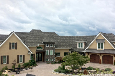 Huge transitional beige three-story brick gable roof idea in Other