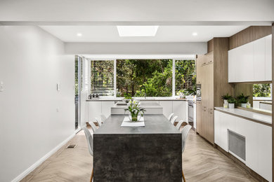 シドニーにある高級な広いコンテンポラリースタイルのおしゃれなダイニングキッチン (白い壁、セラミックタイルの床、ベージュの床) の写真