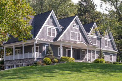Réalisation d'une grande façade de maison bleue tradition en bardeaux à un étage avec un revêtement mixte, un toit à deux pans, un toit en shingle et un toit gris.