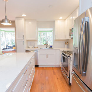 Свежая идея для дизайна: маленькая угловая кухня в стиле современная классика с обеденным столом, одинарной раковиной, фасадами в стиле шейкер, белыми фасадами, столешницей из кварцевого композита, белым фартуком, фартуком из керамической плитки, техникой из нержавеющей стали, паркетным полом среднего тона, островом и красным полом - отличное фото интерьера