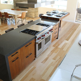 Inspiration for a large modern galley kitchen pantry in Los Angeles with a farmhouse sink, flat-panel cabinets, medium wood cabinets, quartzite benchtops, matchstick tile splashback, stainless steel appliances, light hardwood floors, with island and metallic splashback.