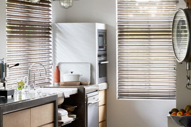Example of a mid-sized urban galley concrete floor and brown floor kitchen design in Phoenix with a drop-in sink, flat-panel cabinets and light wood cabinets