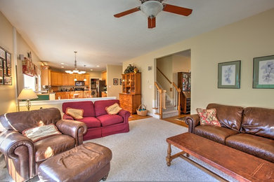 Example of a transitional carpeted living room design in Other with beige walls, a standard fireplace, a wood fireplace surround and a wall-mounted tv