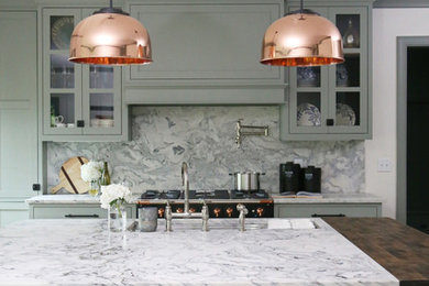 Example of a small transitional l-shaped medium tone wood floor and brown floor eat-in kitchen design in Other with an undermount sink, shaker cabinets, green cabinets, gray backsplash, an island, gray countertops, marble countertops, marble backsplash and stainless steel appliances