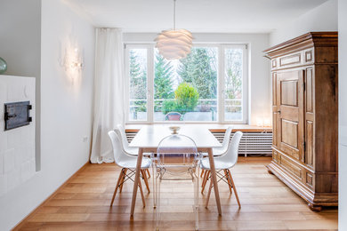 Offenes, Mittelgroßes Skandinavisches Esszimmer mit weißer Wandfarbe, hellem Holzboden und Kaminofen in München