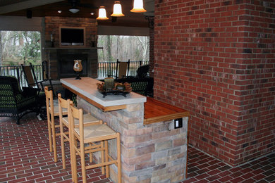 Design ideas for a mid-sized country backyard verandah in Raleigh with an outdoor kitchen, brick pavers and a roof extension.