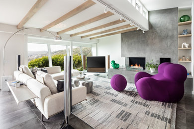 Large trendy open concept porcelain tile and gray floor living room photo in Orange County with white walls, a two-sided fireplace, a concrete fireplace and a tv stand