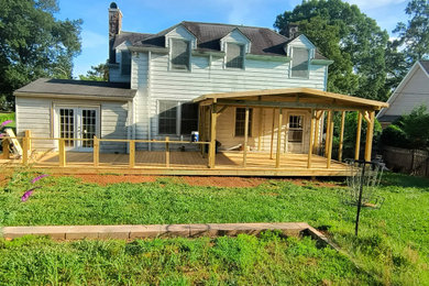 Example of a large cottage backyard ground level deck design in Charlotte