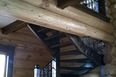 Источник вдохновения для домашнего уюта: большая изогнутая лестница в стиле кантри с деревянными ступенями и металлическими перилами без подступенок
