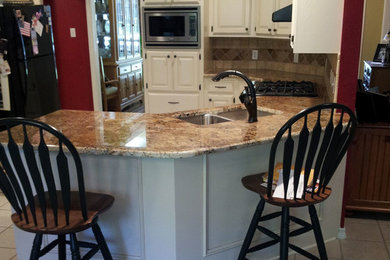 Mid-sized elegant u-shaped beige floor eat-in kitchen photo in Austin with a double-bowl sink, raised-panel cabinets, white cabinets, beige backsplash, black appliances and a peninsula