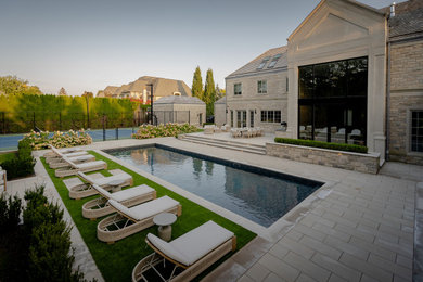 Large trendy backyard concrete paver and rectangular pool landscaping photo in Toronto