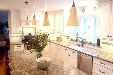 Inspiration for a mid-sized transitional l-shaped medium tone wood floor and brown floor enclosed kitchen remodel in Philadelphia with an undermount sink, stainless steel appliances, recessed-panel cabinets, white cabinets, granite countertops, white backsplash, subway tile backsplash and an island