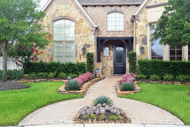 Traditional front yard partial sun garden in Houston with mulch.