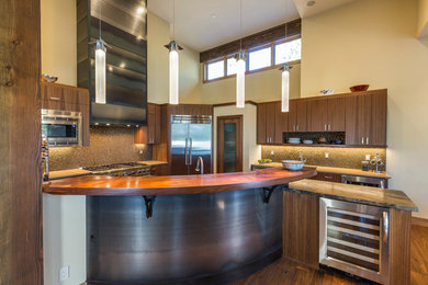 This is an example of a contemporary kitchen in Sacramento with an undermount sink, flat-panel cabinets, medium wood cabinets, wood benchtops, stainless steel appliances, medium hardwood floors and with island.