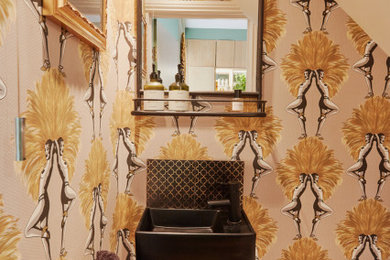 Design ideas for a small eclectic cloakroom in London with black cabinets, a wall mounted toilet, multi-coloured walls, wood-effect flooring, a wall-mounted sink, brown floors, a feature wall, a floating vanity unit and wallpapered walls.