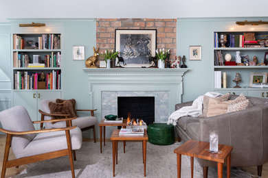 Inspiration for a mid-sized eclectic open concept light wood floor living room library remodel in New York with green walls, a standard fireplace, no tv and a tile fireplace