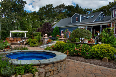 Large traditional backyard full sun garden in New York with natural stone pavers and a water feature.