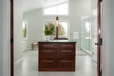 Photo of a large midcentury master bathroom in New York with a vessel sink, flat-panel cabinets, medium wood cabinets, quartzite benchtops, a freestanding tub, a double shower, a one-piece toilet, gray tile, porcelain tile, grey walls and ceramic floors.