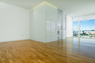 Imagen de salón tipo loft contemporáneo de tamaño medio con paredes blancas, suelo de madera en tonos medios y suelo marrón