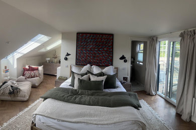 Ejemplo de dormitorio principal escandinavo extra grande con paredes beige, suelo de madera pintada y suelo marrón