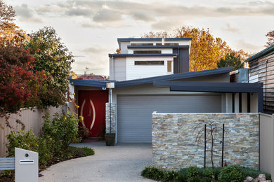 Design ideas for a large contemporary three-storey multi-coloured house exterior in Melbourne with mixed siding, a flat roof and a metal roof.