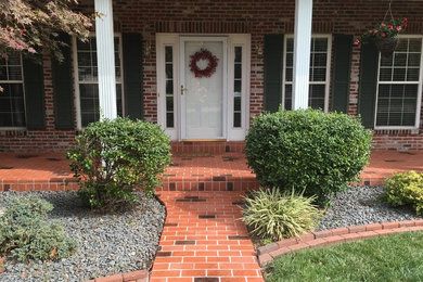Photo of a mid-sized traditional front door in St Louis with multi-coloured walls, brick floors, a single front door and a white front door.