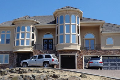 Inspiration for a large timeless beige three-story stucco exterior home remodel in Denver with a hip roof