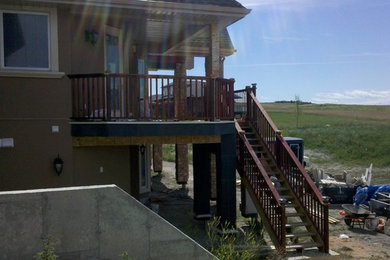 Deck - large traditional backyard deck idea in Calgary